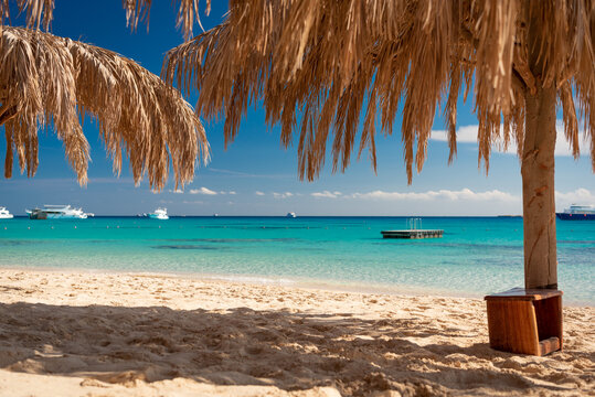 Mahmya Island, Rotes Meer, &Auml;gypten mit Schwimminsel und Booten. Wolkenbild und Palmenwedeln mit blauem Himmel. 