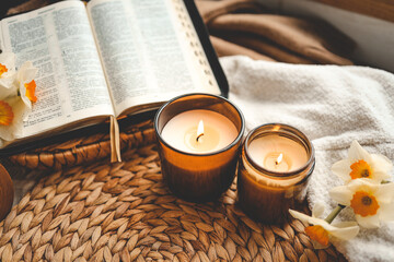 Open Bible with flowers and candles in a cozy home interior. Christian beautiful morning...