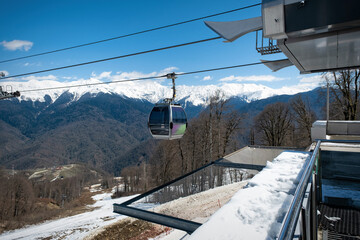 The cabin of the ski lift against the background of the blue sky and mountains in the ski resort on...