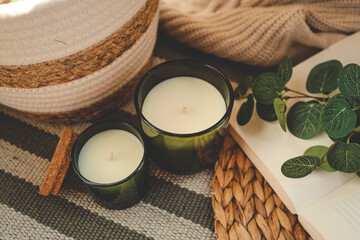 Two candles and a basket with daffodils in a home interior