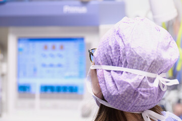 Lekarz, pielęgniarka anestezjologiczna patrzą w kardiomonitor, monitor aparatu do znieczuleń, obserwują parametry życiowe operowanego  pacjenta.