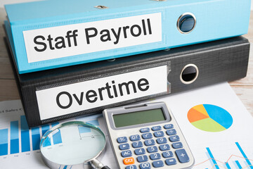 Staff Payroll, Overtime. Binder data finance report business with graph analysis in office.