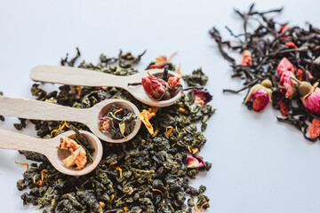Fototapeta premium Herbal different types of tea and wooden spoons on white background top view