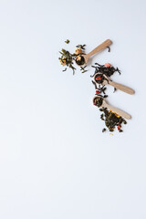Assortment of craft loose leaf teas on white background, top view