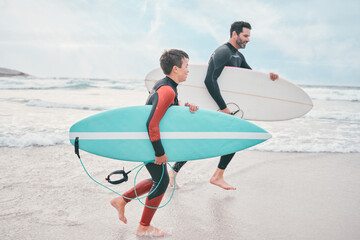 We only things we chase, is waves. Shot of a man and his young son at the beach with their...
