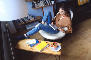 Young relaxed casual woman reading and enjoying tranquility and leisure time at home.