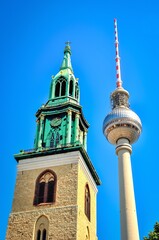 Fototapeta na wymiar Berlin, Germany - May 03, 2014: TV Tower in Berlin, Germany. Old and new in Berlin: view towards the tower of St. Mary is Church (Marienkirche) and Berliner Fernsehturm in Alexanderplatz.