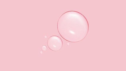 Drops of transparent gel or water in different sizes. On a pink background.