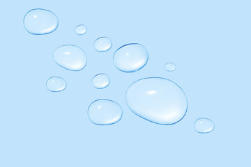 Drops of transparent gel or water in different sizes. On a blue background.