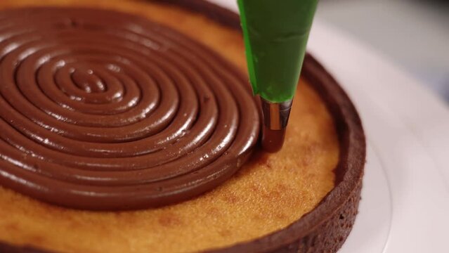 Filling traditional tart with tasty chocolate cream on stand