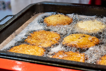 Delicious tasty potato pancakes frying in hot oil, Polish placki ziemniaczane detail, closeup,...