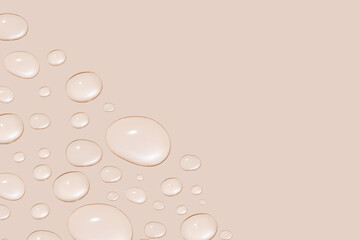 Drops of transparent gel or water in different sizes. On a beige background.