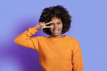 Fototapeta na wymiar Portrait of cool stylish young black woman posing on purple
