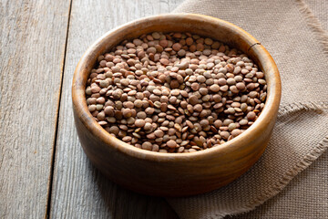 raw lentils in a bowl on an old wooden table