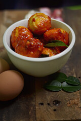 Balado Egg Sambal, a typical Indonesian food. on a wooden board