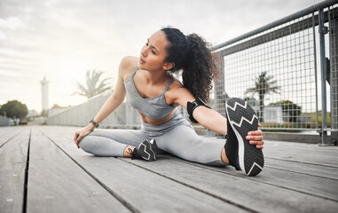 Shes just about ready. Full length shot of an attractive young female athlete warming up before her...