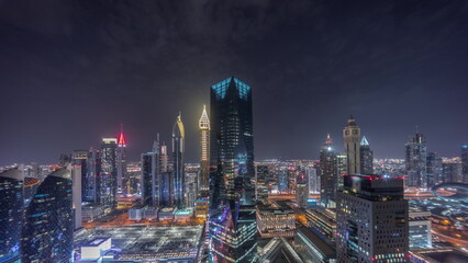 Fototapeta premium Panorama of futuristic skyscrapers in financial district business center in Dubai night timelapse
