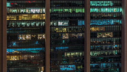 Fototapeta na wymiar Big glowing windows in modern office buildings timelapse at night