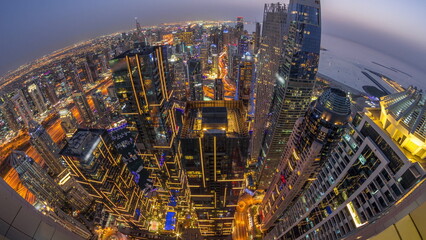 Skyline panorama of Dubai Marina showing canal surrounded by skyscrapers along shoreline day to...