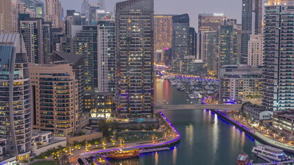 Dubai Marina with several boat and yachts parked in harbor and skyscrapers around canal aerial day...