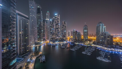 Fototapeta premium Dubai marina tallest skyscrapers and yachts in harbor aerial all night timelapse.