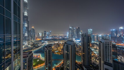Dubai downtown with fountains and modern futuristic architecture aerial all night timelapse