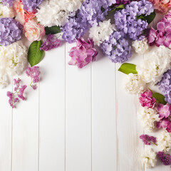 A white wood background topped with lots of beautiful white, pink and violet flowers , blank space and text space. Abstract natural floral layout with text space and copy space. Wedding invitation. In