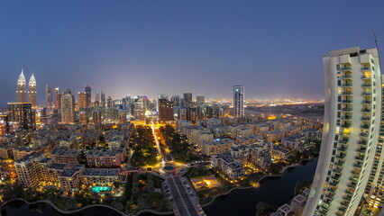 Fototapeta na wymiar Panorama with skyscrapers in Barsha Heights district and low rise buildings in Greens district aerial day to night timelapse.