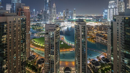 Naklejka premium Panorama showing Dubai Downtown cityscape with tallest skyscrapers around aerial night timelapse.