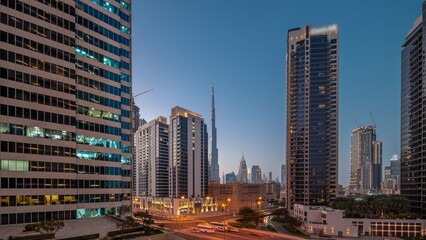Naklejka na ściany i meble Aerial panoramic view to Dubai downtown and difc skyscrapers day to night timelapse.