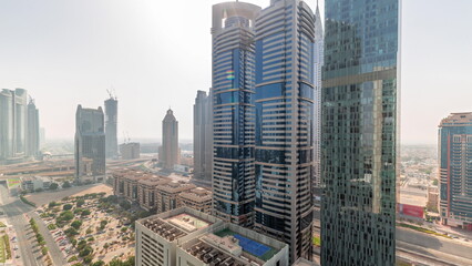 Aerial view of Dubai International Financial District with many skyscrapers all day timelapse.