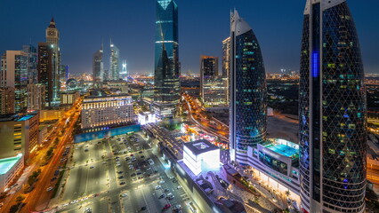 Fototapeta premium Aerial view of Dubai International Financial District with many skyscrapers day to night timelapse.