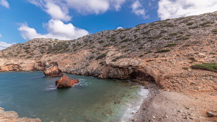 An abandoned rusty ship in the sea timelapse near huge rock formations in Navagio Beach, Amorgos Island, Greece