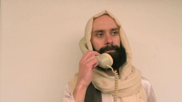 young pensive bearded and mustachioed man, guy with 30 years old in image of Savior, Jesus Christ holding landline phone, ask follow or following offer, offering, communication with people, helpline