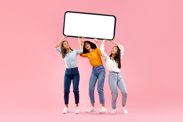 Cellphone display template. Three diverse ladies holding huge smartphone with blank screen over pink background, mockup