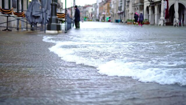 Strong streams of flood water cover small city streets