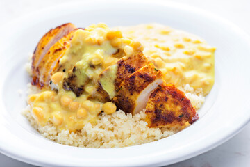 chicken breast served with creamy curry chickpea sauce and couscous