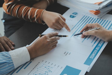 Financial analysts analyze business financial reports on a digital tablet planning investment project during a discussion at a meeting of corporate showing the results of their successful teamwork.