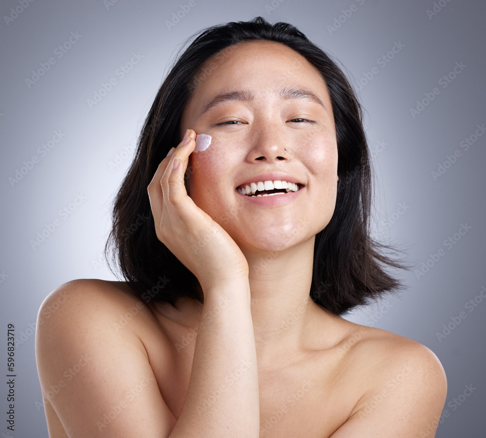 Poster Keep your skin happy. Shot of a young woman applying lotion against a grey background.