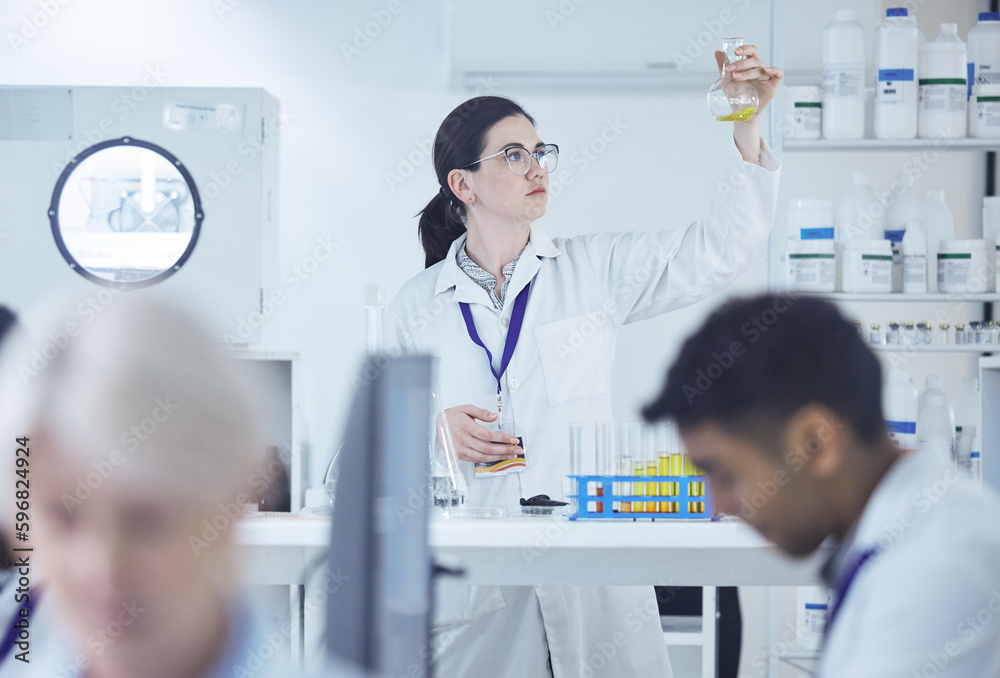 Poster putting in the work. shot of a group of scientists working together.