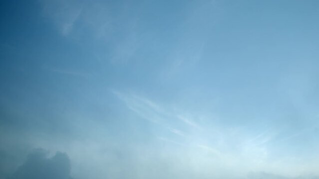 White, translucent cirrus clouds slowly drift across the sky