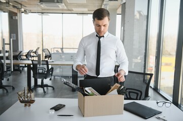 Sad Fired. Let Go Office Worker Packs His Belongings into Cardboard Box and Leaves Office. Workforce Reduction, Downsizing, Reorganization, Restructuring, Outsourcing. Mass Unemployment Market Crisis
