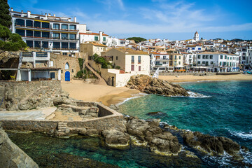 Fototapeta premium A classic white town on the Costa Brava. White houses, historical buildings of Calella de Palafrugell. Rocks, beach and sea view