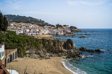 Fototapeta na wymiar A classic white town on the Costa Brava. White houses, historical buildings of Calella de Palafrugell. Rocks, beach and sea view