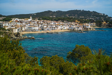 Fototapeta premium A classic white town on the Costa Brava. White houses, historical buildings of Calella de Palafrugell. Rocks, beach and sea view
