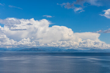 A beautiful landscape of the coast of the island of Corfu in the Ionian Sea of the Mediterranean in Greece. Pure blue clear water washes over the shores of the Greek island.