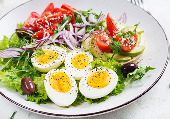 Fresh  salad with tomato, olives, boiled eggs and and sandwich with  ricotta cheese, avocado.