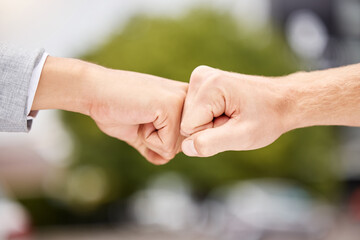 Well make a great team. Shot of two unrecognizable businesspeople giving each other a fist bump in the city.