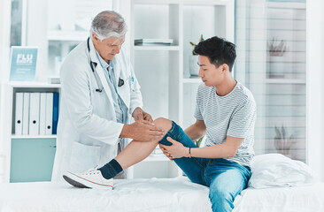 Some injuries are undetectable. Shot of a mature doctor checking his patients knee for injury.