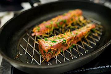 Closeup photo of two grilled red fish salmon steaks on cast iron skillet pan